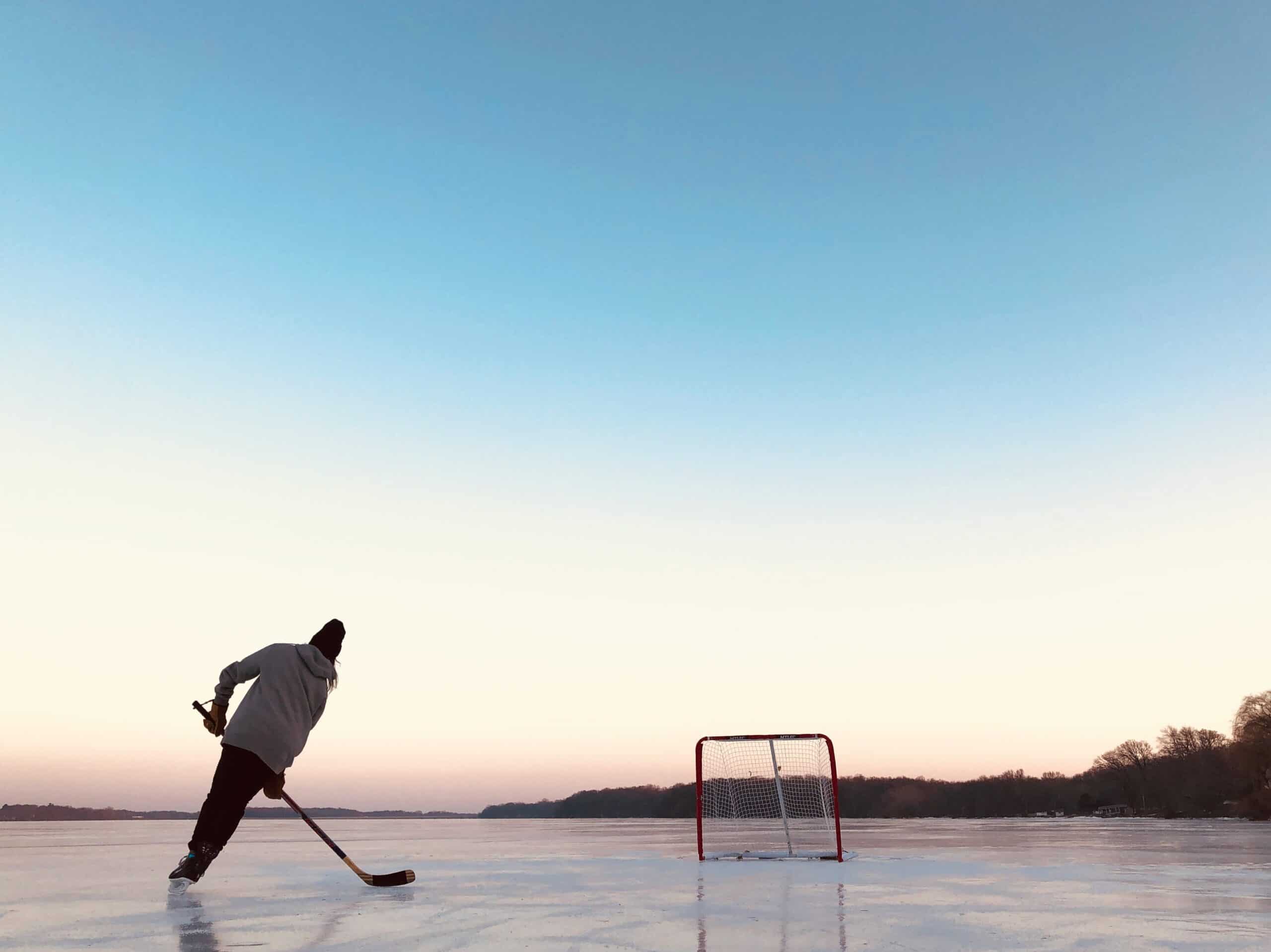 a hockey player skating and shooting pucks outdoor