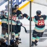 the seattle kraken celebrating a goal during an nhl game