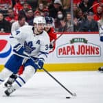 Auston Matthews skating with the puck and John Tavares during an NHL hockey game