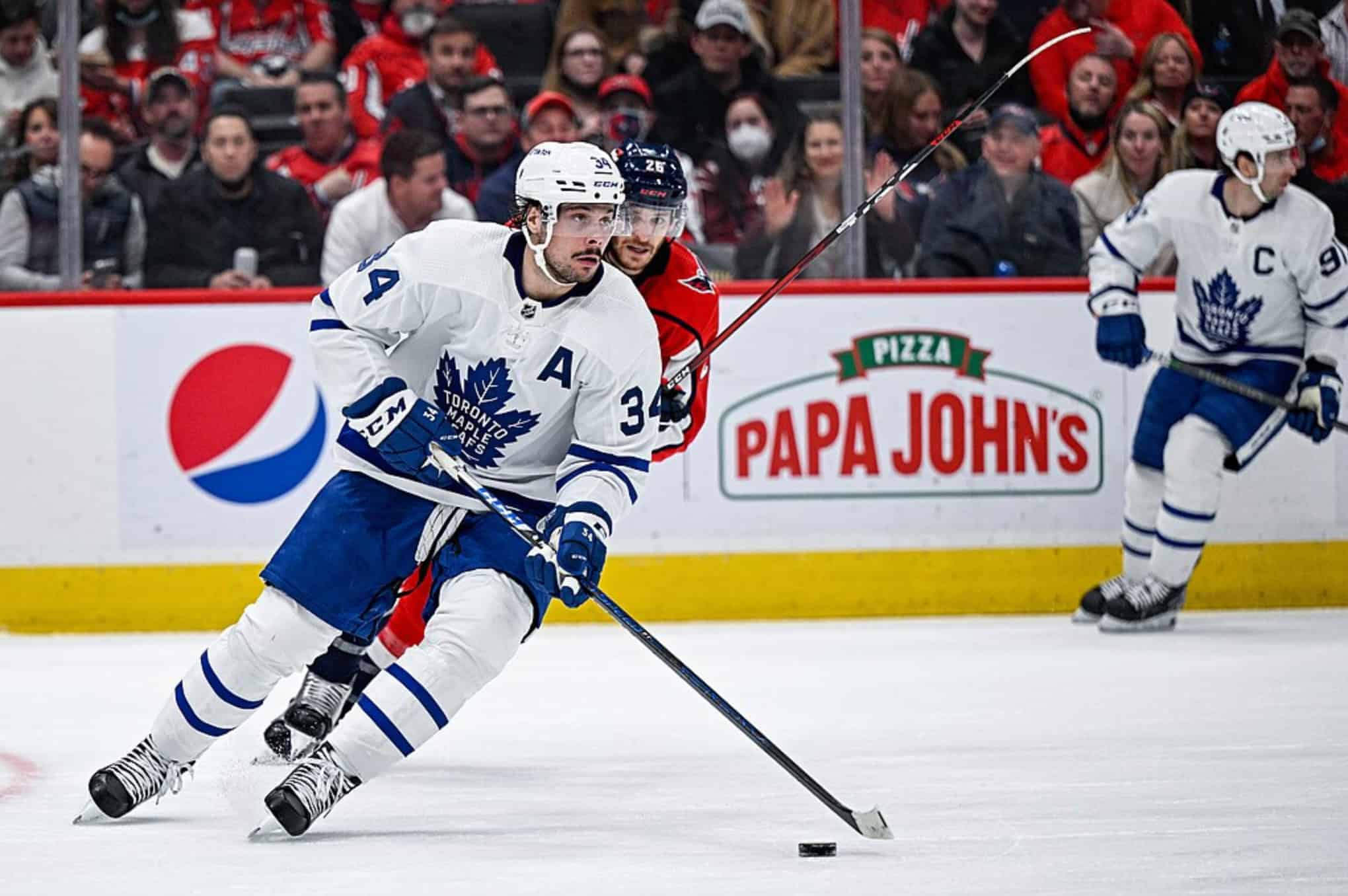 Auston Matthews skating with the puck and John Tavares during an NHL hockey game