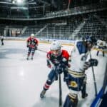 a body check along the boards during an ice hockey game with children playing