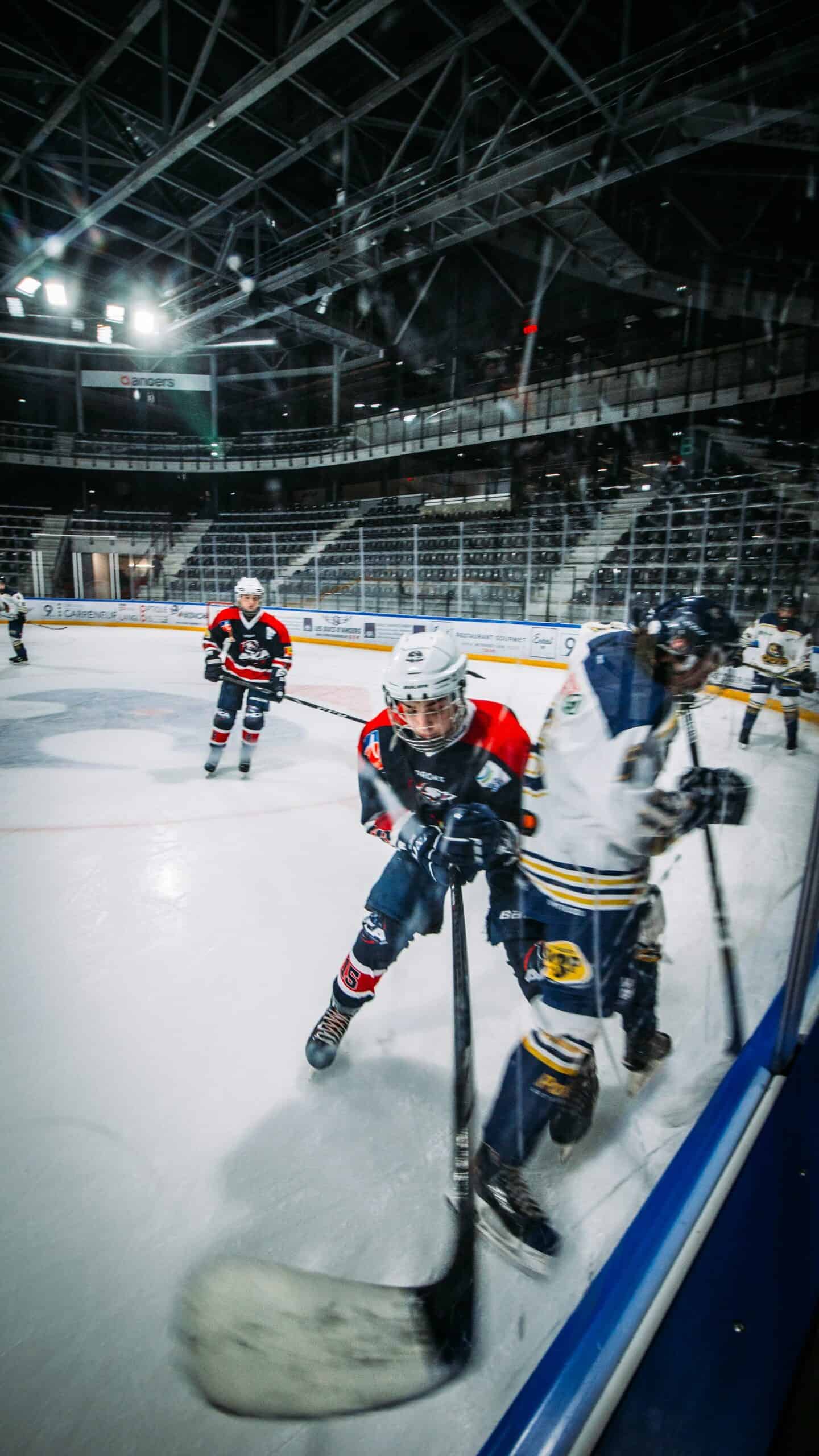 a body check along the boards during an ice hockey game with children playing