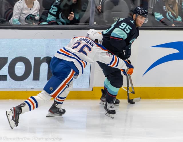 Mattias Janmark and Andre Burakovsky battling along the boards during an NHL game.